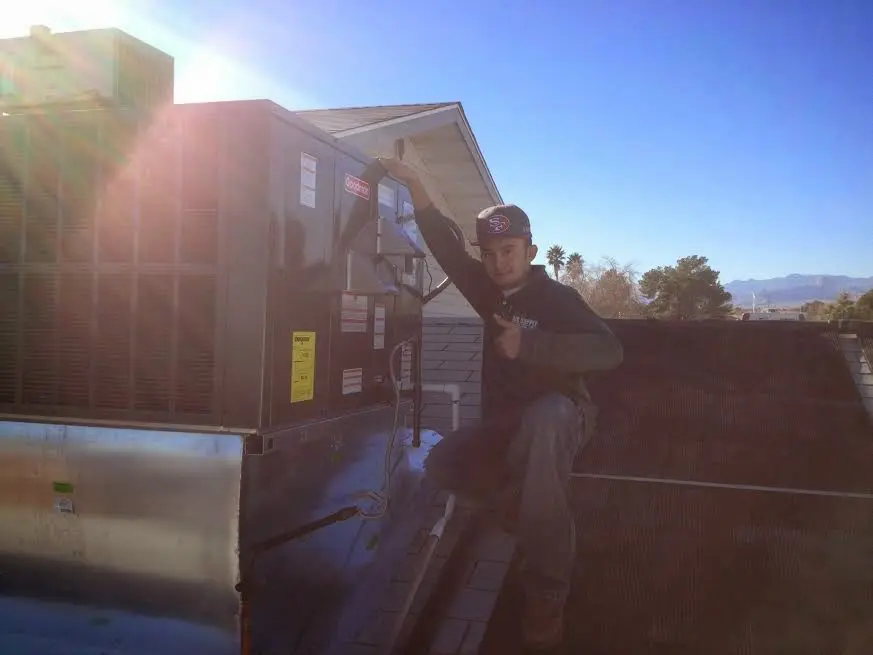 HVAC technician performing Heat Pump Repair on a rooftop unit in Plano